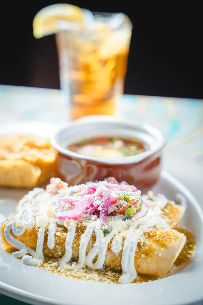 Enchiladas verdes with crema and pickled onion